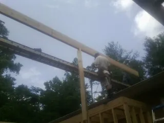 Carpenter setting a ridge beam over a new addition frame — Ice Dam Removal by Roofing Brothers in Vermont