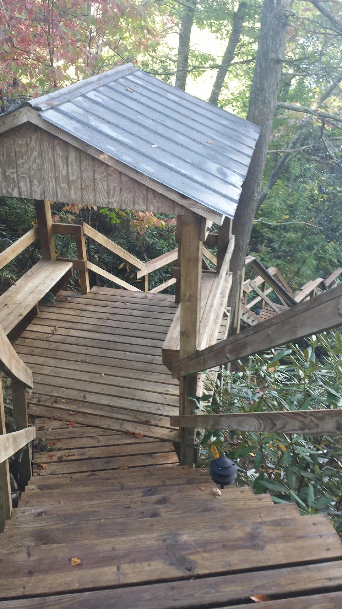 Metal roofed shelter over wooden steps on a wooded walkway — Skylight Repair & Installation work by our crew in Vermont