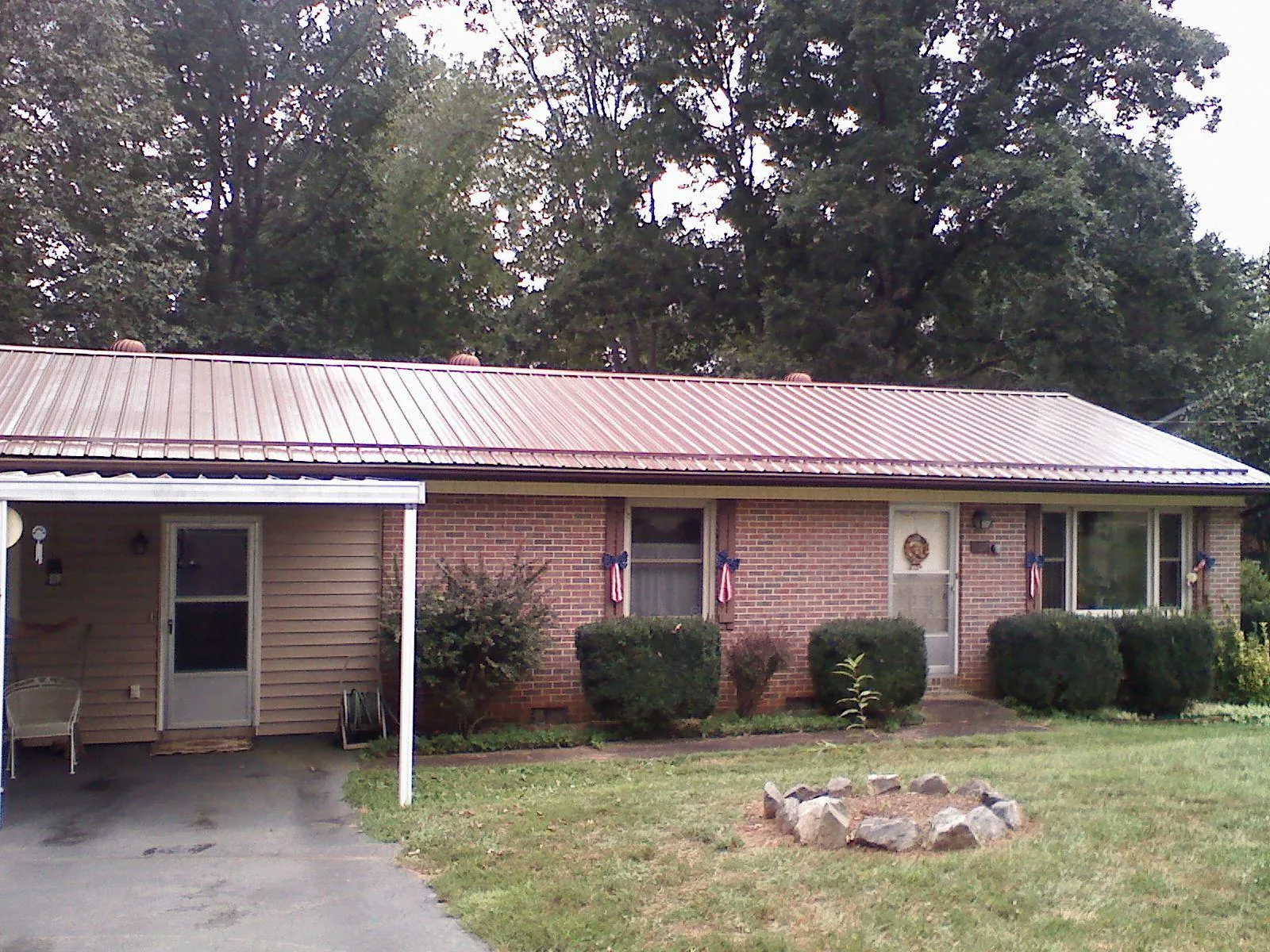 Bronze metal roof and carport on a brick ranch home — Roof Repair work by our crew in Vermont